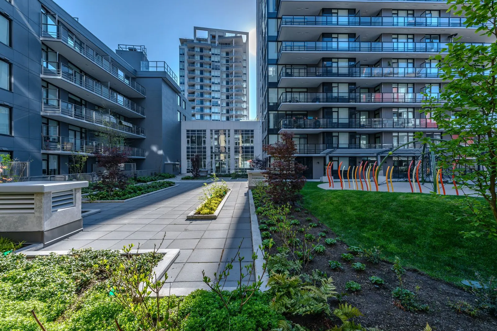 Courtyard walkway with lawn and planting between buildings at Quartet