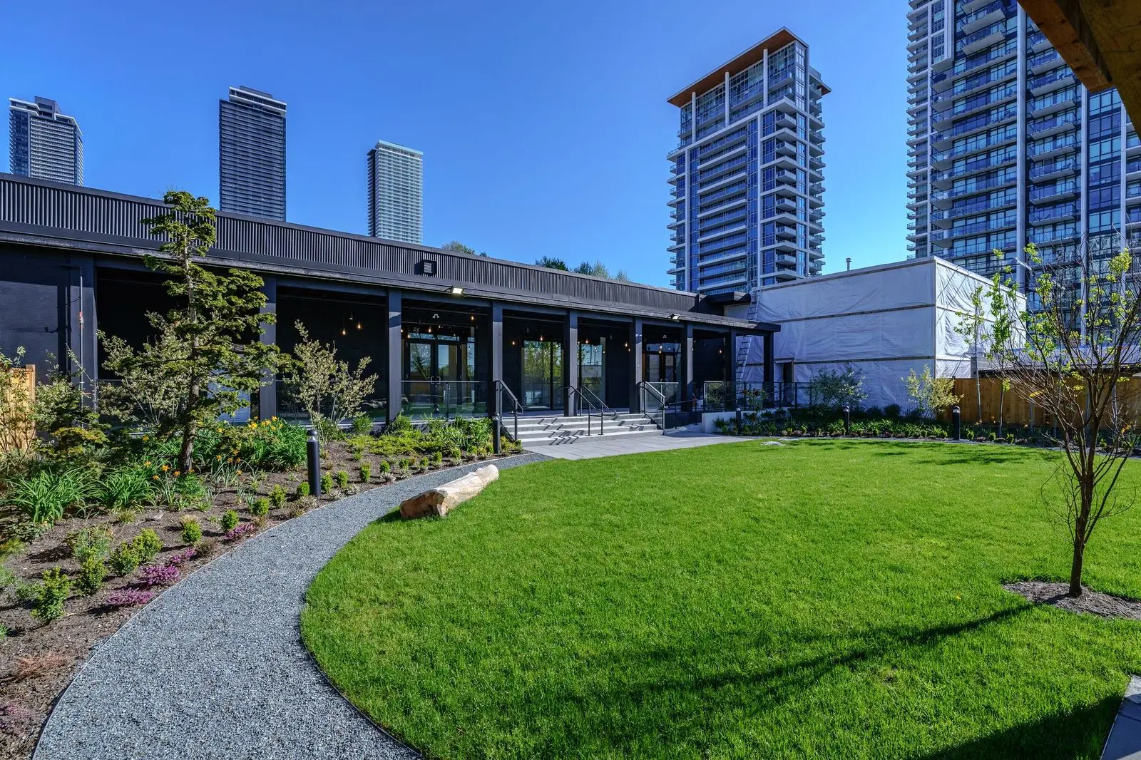 Lawn and gravel path in front of a low building at The Grove Presentation Centre