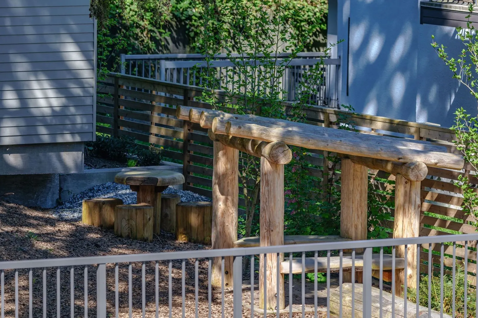 Timber play structure behind a fence at Conrad