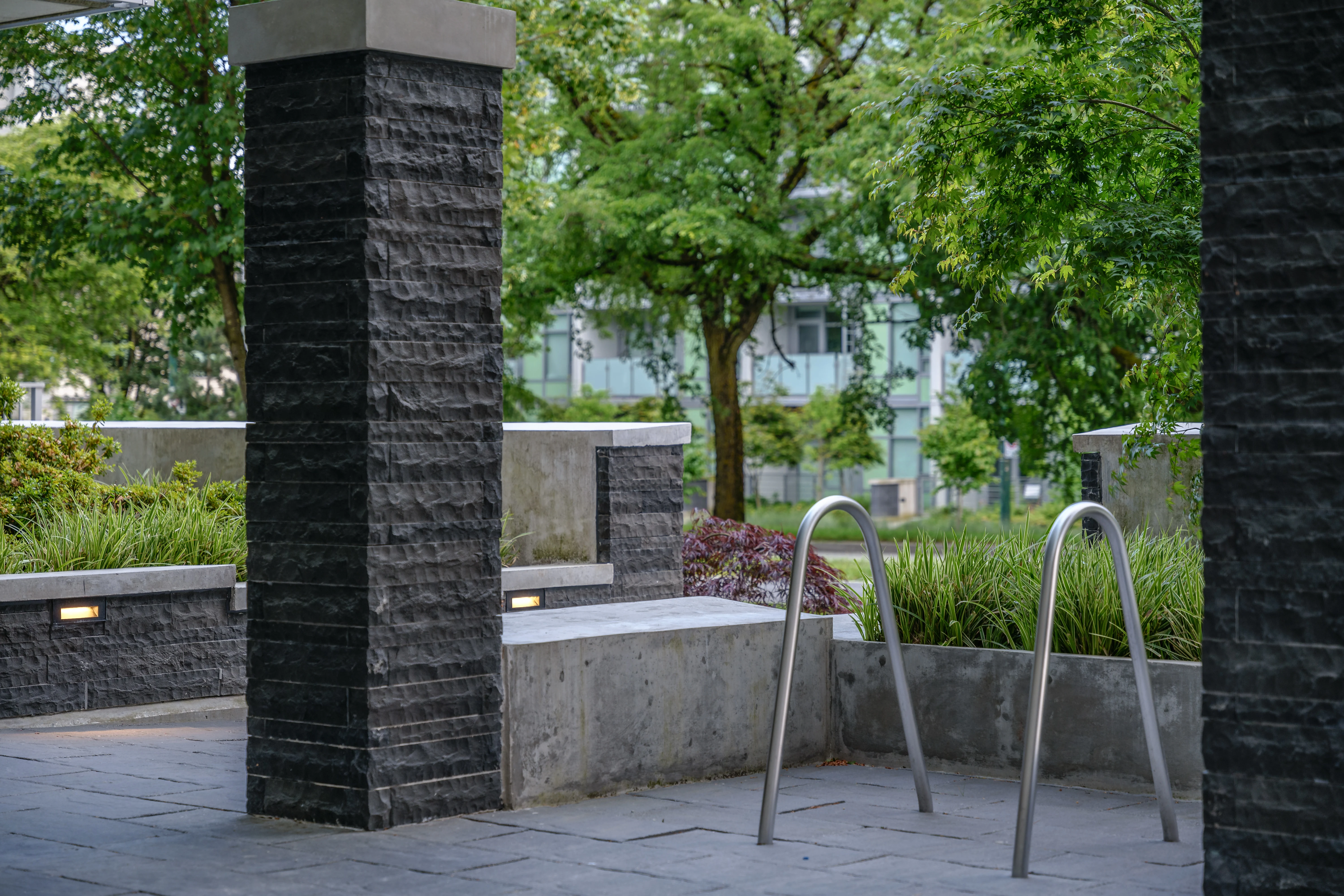 Stone-clad columns framing a courtyard with planting at Basalt