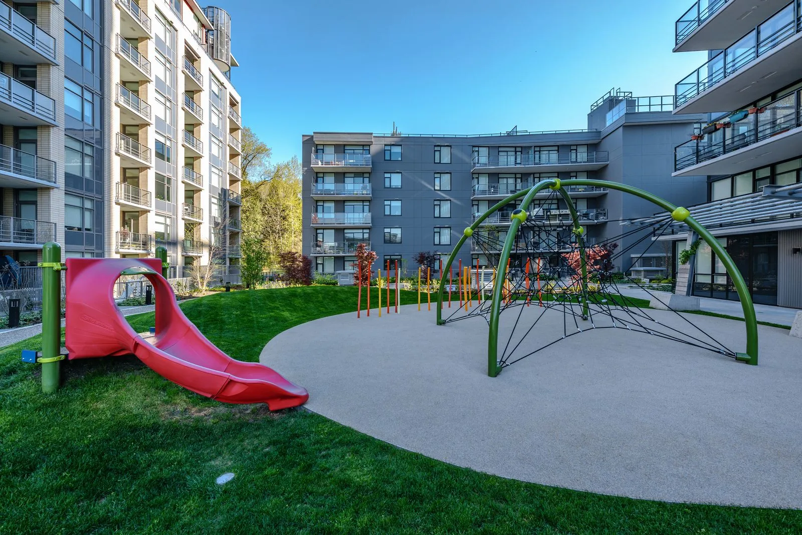 Courtyard play area with slide and climbing dome on lawn at Quartet