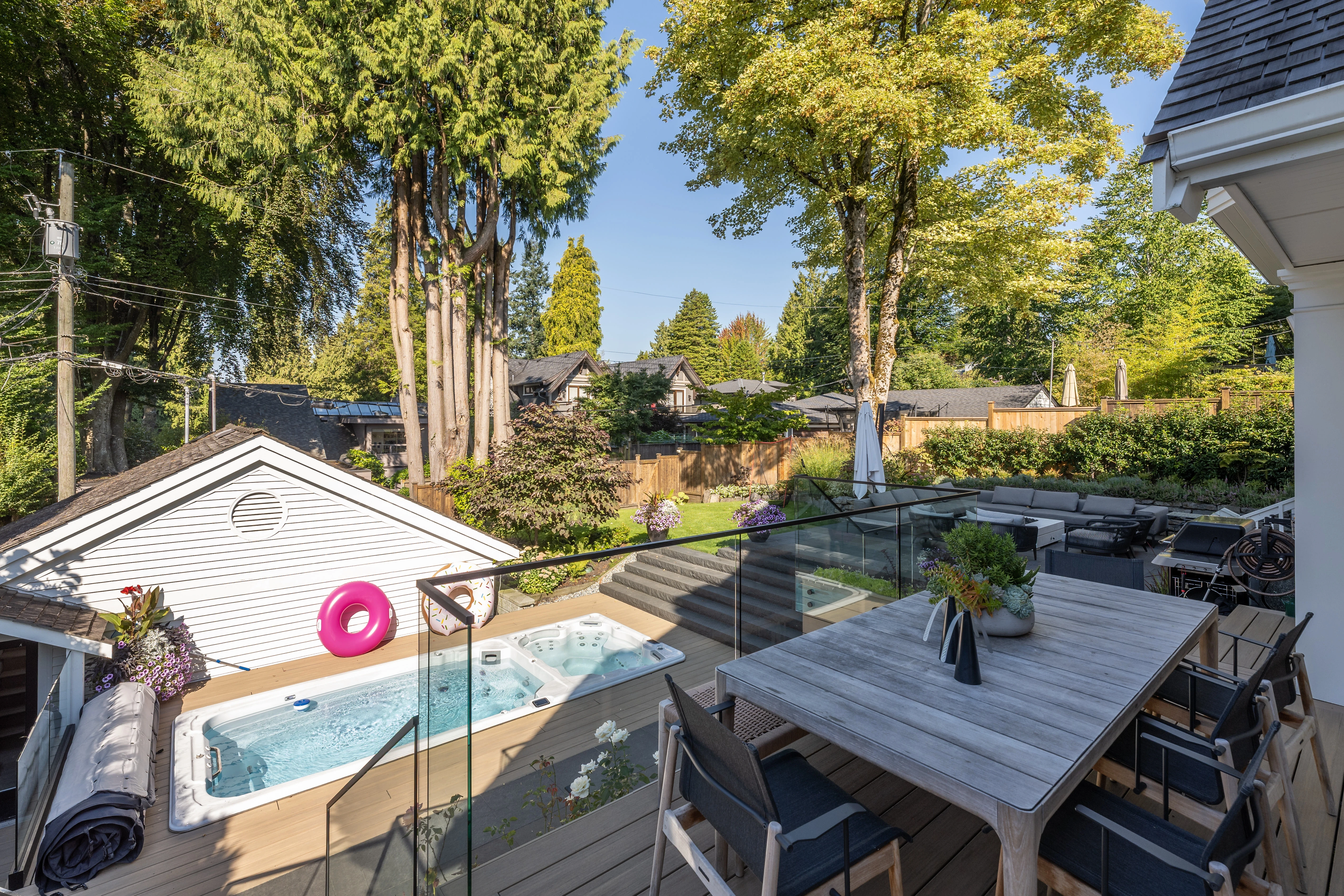 Backyard dining area beside a swim spa at MacKenzie
