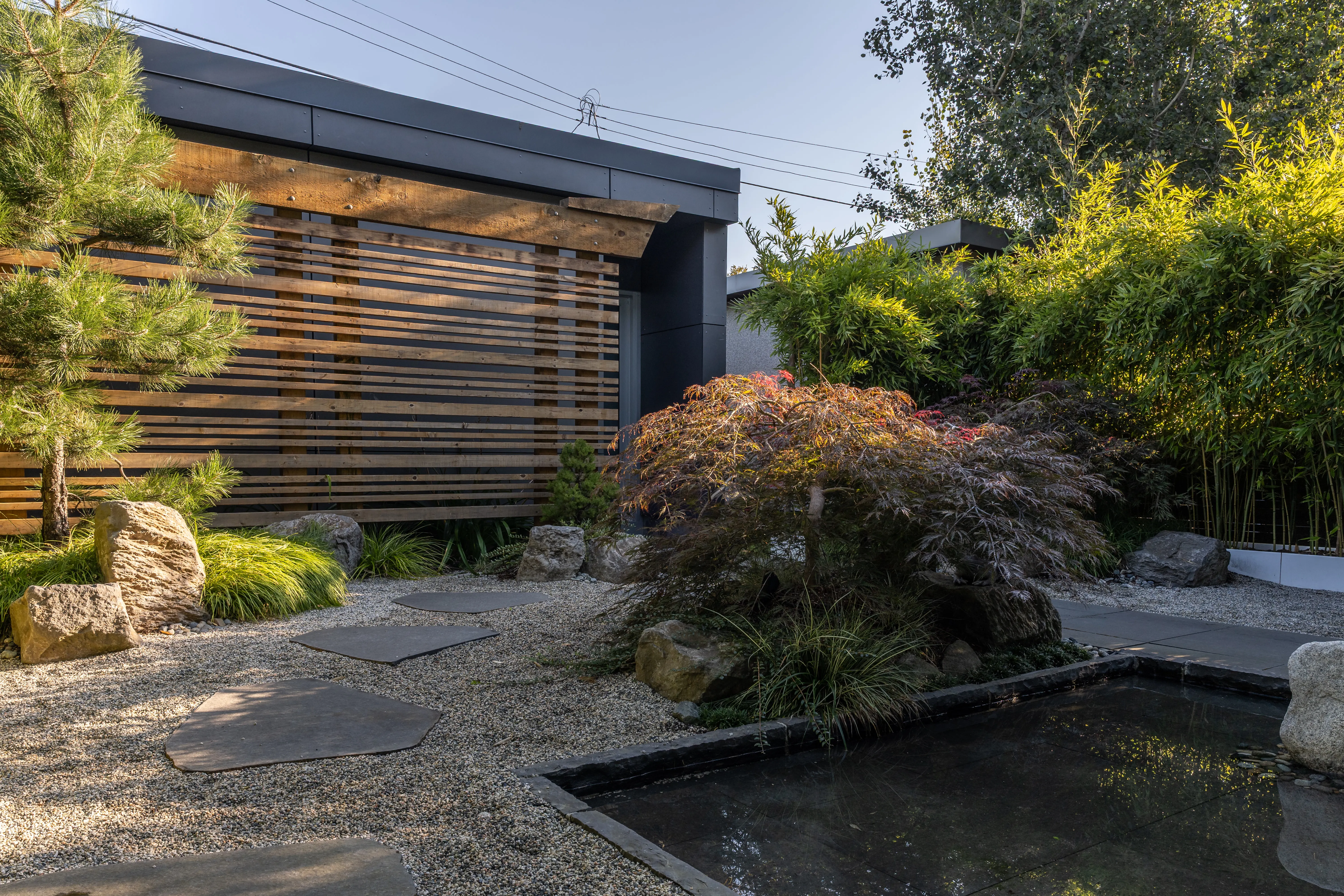 Gravel garden with reflecting pool and red-leaf shrub at West 9th