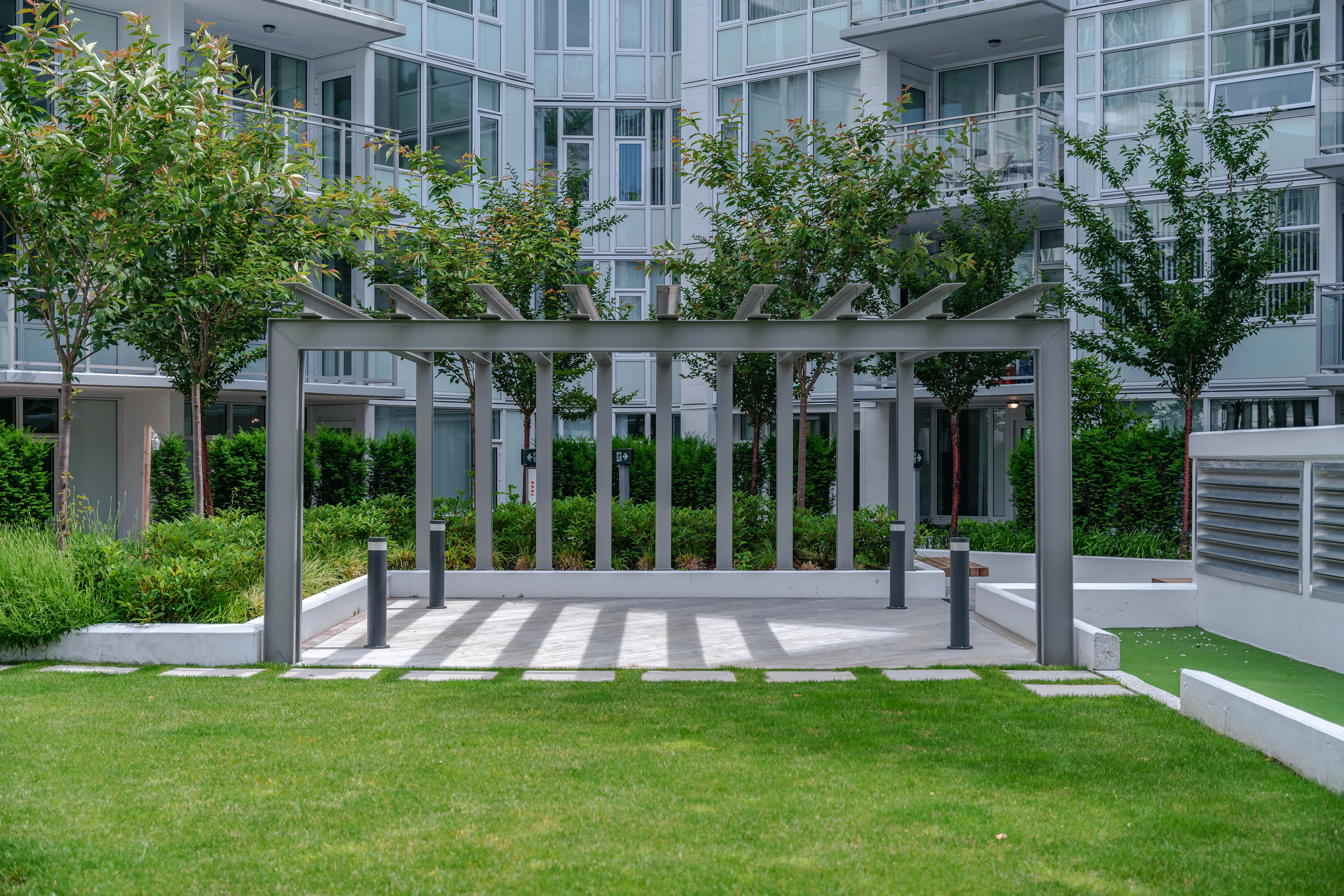 Pergola over a paved strip in a courtyard lawn at Torino
