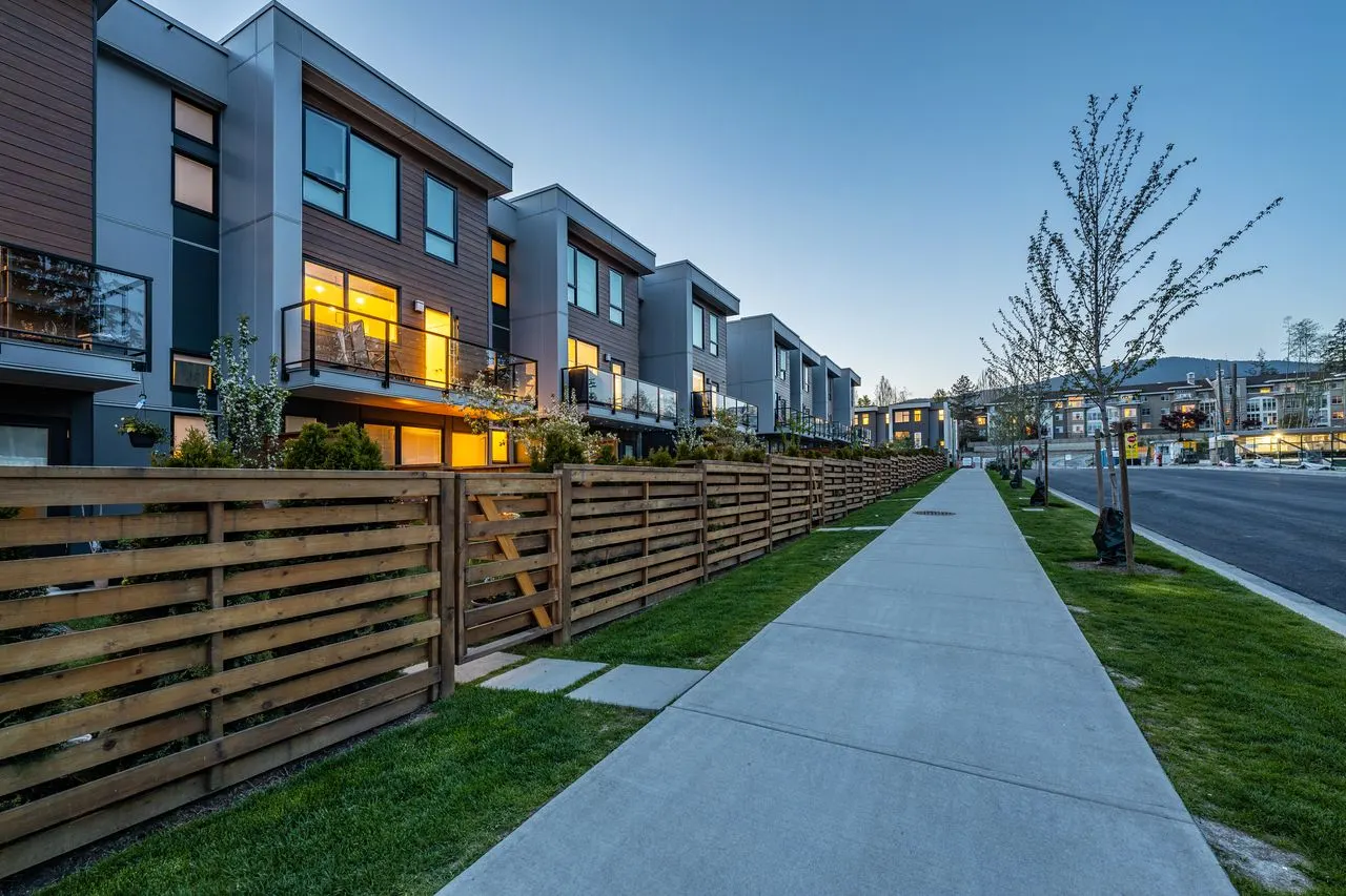 Sidewalk along timber fences and lawn at townhomes at Seymour Village Amenity Park