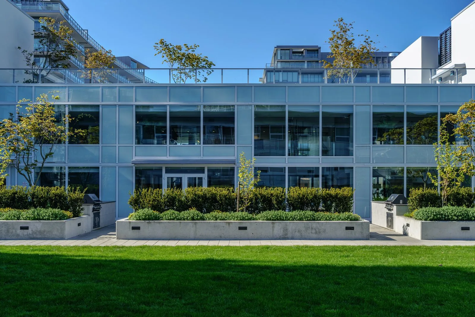 Lawn and hedge planters in front of a building at River Park Place 2