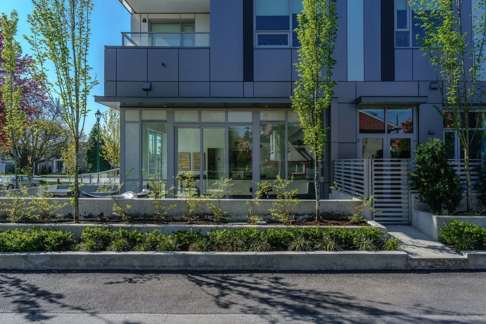 Columnar trees and low planting along a building frontage at The Parker