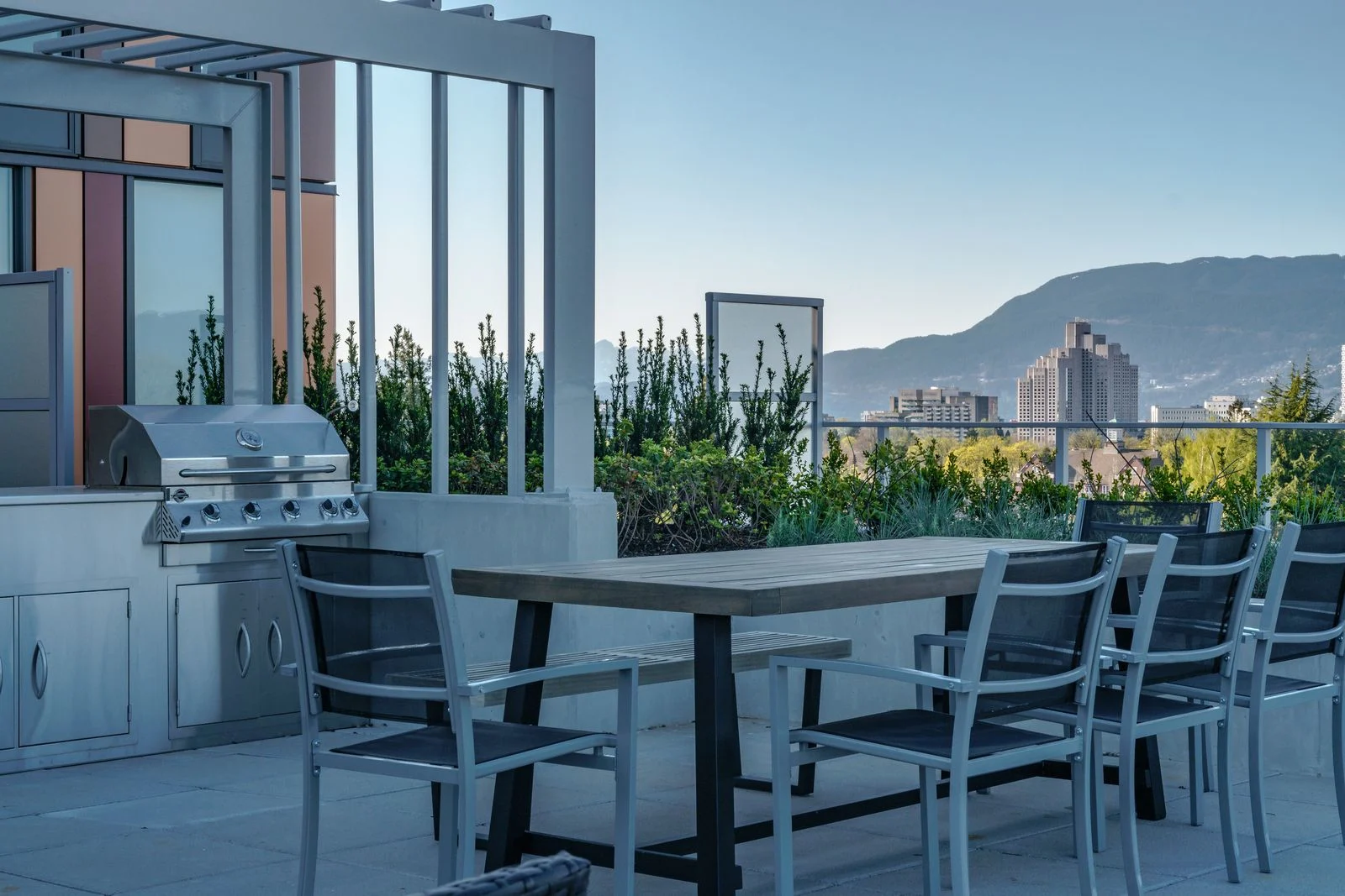 Rooftop dining table, barbecue and planters with mountain views at Marquise