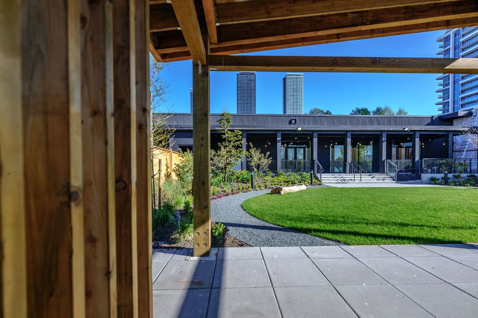 Lawn framed by timber pavilion posts at The Grove Presentation Centre
