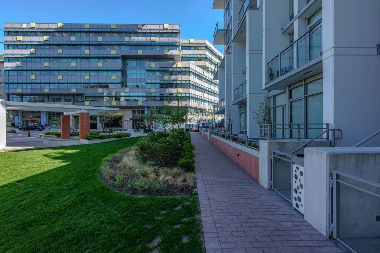 Lawn and paver walkway beside a residential building at Brewery District 6