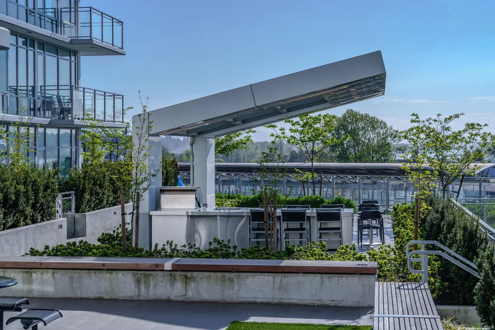 Covered outdoor kitchen on a planted rooftop terrace at Brewery District 6