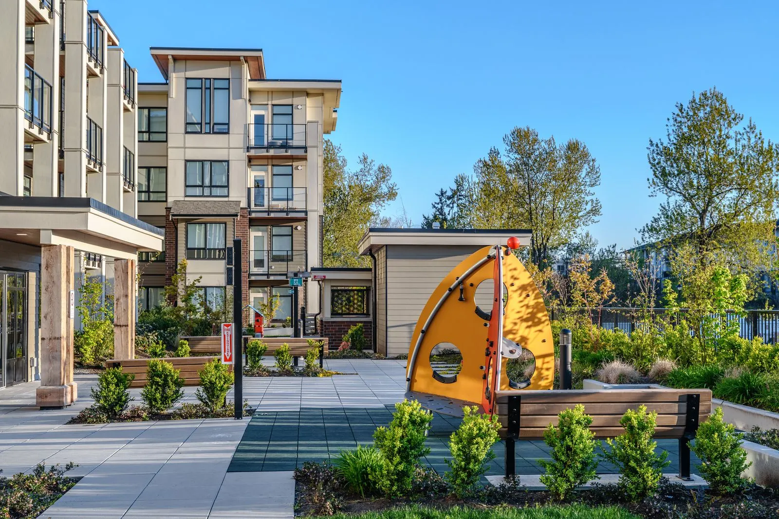 Play feature and planting beds in a paved courtyard at Spark